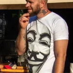 Фото тату на шее мужчины: татуировка в стиле олдскул, детализированные элементы, черно-белые тона. Идеи для татуировок на шее.