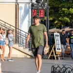 Фото тату: рукав татуировки, покрывающий руку, с изображением реалистичных цветов и узоров. Детализированный рисунок татуировки в теплых тонах.