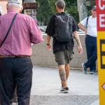 Фото мужчины с татуировкой на ноге, снятое сзади. Татуировка выполнена в черно-серых тонах, изображает, вероятно, животное или мифологического персонажа.