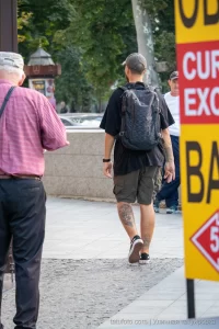 Фото мужчины с татуировкой на ноге, снятое сзади. Татуировка выполнена в черно-серых тонах, изображает, вероятно, животное или мифологического персонажа.