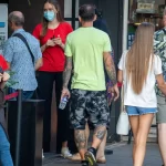 Фото мужчины с обширной татуировкой на руке, покрывающей большую часть плеча и предплечья. Видны детализированные рисунки в стиле традиционный.