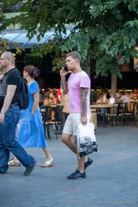 Фото мужчины с татуировкой на предплечье и шее, выполненной в стиле blackwork. Видна часть татуировки на руке и шее, мужчина разговаривает по телефону.