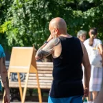 Фото тату: большая татуировка на плече мужчины, с изображением ярких цветов и абстрактных элементов, выполненная в смешанном стиле.