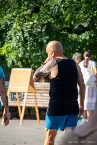 Фото тату: большая татуировка на плече мужчины, с изображением ярких цветов и абстрактных элементов, выполненная в смешанном стиле.