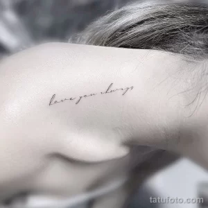 Минималистичная татуировка надписью 'love you always' на шее, выполненная тонким, изящным шрифтом. Татуировка выглядит романтично и трогательно.