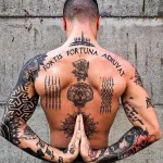 Фото тату на мужской спине: реалистичное изображение головы тигра, роза, геометрические узоры и надпись на латыни.