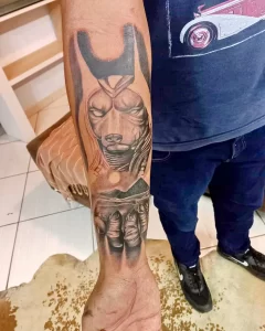 Фото татуировки с изображением Эдди, талисмана группы Iron Maiden, на руке. Реалистичный рисунок в черно-серых тонах, передающий агрессивный образ персонажа.