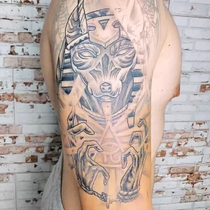 Фото татуировки Анубиса, выполненной в технике dotwork. Изображение бога с головой шакала, созданное из множества точек. Современный стиль тату.
