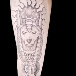 Фото татуировки Анубиса в стиле dotwork, выполненной с использованием точек и штрихов на предплечье.