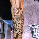 Фото татуировки Анубиса на руке в стиле blackwork. Изображение бога с использованием только черных линий и точек.