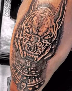 Фото тату Анубиса на плече в стиле blackwork. Черно-белый рисунок с акцентом на контуры и детализацию.