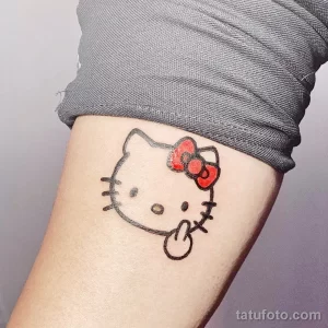 Фото тату Hello Kitty на руке. Простой черно-белый рисунок татуировки с изображением знаменитого персонажа.