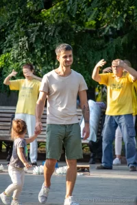 Фото тату на руке мужчины, держащего за руку маленькую девочку. Татуировка изображает темные деревья на фоне светлой кожи.