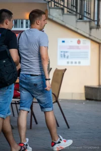 Фото тату на руке мужчины: крупный план темного растительного орнамента, обвивающего предплечье. Татуировка выполнена в графическом стиле.