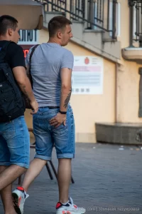 Фото тату на руке мужчины: темный растительный орнамент, обвивающий предплечье. Татуировка выполнена в графическом стиле.