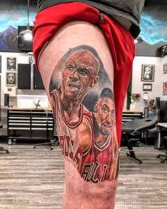 Фото тату на бедре: портреты Майкла Джордана и Демара Дерозана в форме Chicago Bulls. Высокодетализированный реализм с яркими цветами.