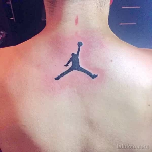 Фото тату на шее с изображением логотипа Jumpman (силуэт Майкла Джордана в прыжке). Черная татуировка в минималистичном стиле.