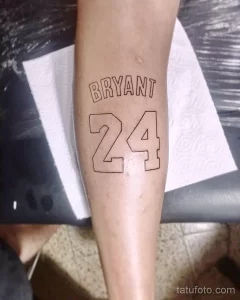 Фото минималистичной татуировки с надписью "BRYANT" и номером "24" на руке. Черно-белый рисунок, четкие линии.
