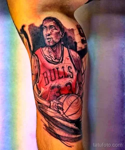 Фото тату на руке: реалистичный портрет Майкла Джордана в форме Chicago Bulls с баскетбольным мячом. Детализированный эскиз тату для фанатов баскетбола.