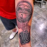 Фото тату реалистичного изображения баскетбольного мяча Spalding с надписью "Yoyo 4 Life" и номером 10 на руке.