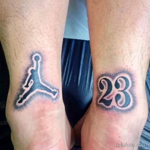 Фото двух минималистичных татуировок на лодыжках: логотип Jumpman и номер 23. Черно-белый рисунок, простой стиль.