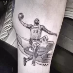Фото тату реалистичного портрета Леброна Джеймса в форме игрока Lakers. Детализированная прорисовка, черно-белая гамма, динамичная поза.