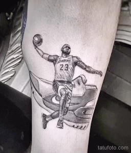 Фото тату реалистичного портрета Леброна Джеймса в форме игрока Lakers. Детализированная прорисовка, черно-белая гамма, динамичная поза.