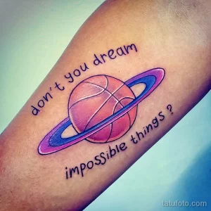 Фото тату планеты Сатурн с надписью 'Don't you dream impossible things?'. Нежные пастельные тона, минималистичный стиль.