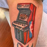 Фото тату на руке: красочное изображение игрового автомата NBA Jam в стиле ретро. Рисунок выполнен в ярких цветах с проработкой деталей.