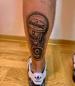 Фото тату на икре: красочный рисунок баскетбольного мяча Spalding с надписью 'Ball is life'. Детализированный эскиз татуировки.