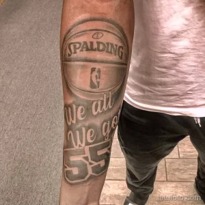 Фото тату на руке: Изображение баскетбольного мяча Spalding с надписью "We all We got". Черно-белый рисунок татуировки.
