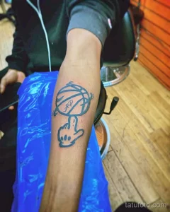 Фото тату на руке: минималистичное изображение баскетбольного мяча и руки, показывающей жест. Черно-белый дизайн.