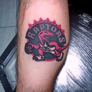 Фото татуировки на ноге с изображением логотипа баскетбольной команды "Toronto Raptors". Яркий рисунок татуировки.
