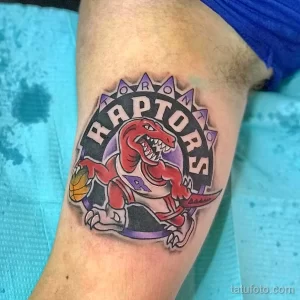 Фото тату на руке: логотип баскетбольной команды Toronto Raptors, яркие цвета, детализированный рисунок. Идея для фаната баскетбола.