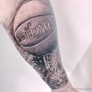 Фото тату реалистичного баскетбольного мяча Spalding на предплечье, выполненного в черно-серых тонах с высокой детализацией и эффектом объема.
