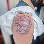 Фото тату с изображением головы быка в стиле blackwork, выполненное на плече. Татуировка отличается четкими линиями и контрастным затенением.