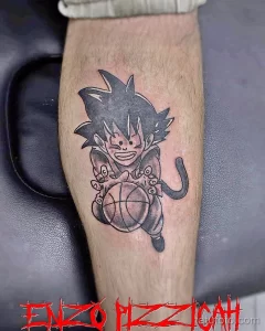 Фото тату с изображением аниме-персонажа Гоку из Dragon Ball Z на предплечье, выполненное в ярких цветах и четких линиях.