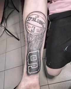 Фото татуировки на предплечье, изображающей баскетбольный мяч Spalding с номером 9 и надписью "Ball is life". Символизирует страсть к баскетболу и преданность игре.