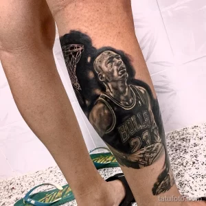 Фото реалистичной татуировки Майкла Джордана в форме Chicago Bulls, выполненной в черно-белом стиле на ноге.