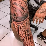 Фото тату на предплечье с изображением баскетбольного мяча Spalding и надписью 'Ball is Life' в реалистичном стиле.