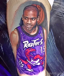 Фото реалистичного тату с изображением баскетболиста Винса Картера в форме Toronto Raptors на руке. Детализированный портрет с баскетбольным мячом.