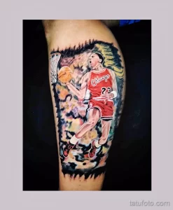 Фото тату с изображением Майкла Джордана в красной форме Chicago Bulls, забивающего мяч в корзину. Яркие цвета и динамичная композиция.