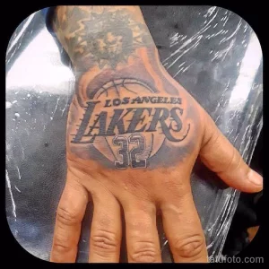 Фото татуировки на ладони с изображением логотипа LA Lakers и номером 32. Смелый и заметный рисунок для фанатов баскетбола.
