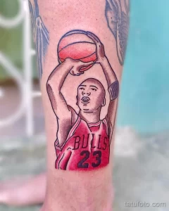 Фото тату на руке с изображением Майкла Джордана в красной форме Chicago Bulls. Рисунок выполнен в ярких цветах с использованием красного, черного и белого.