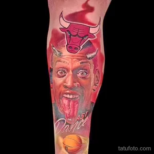 Фото тату на руке с изображением Майкла Джордана, высунувшего язык, и логотипа Chicago Bulls. Яркие цвета и динамичная композиция.