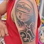 Фото тату на плече с изображением баскетбольного мяча Spalding, надписи 'Big Boys' и номера '21'. Яркий и стильный дизайн.