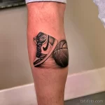 Фото тату на ноге с изображением кроссовка Air Jordan и баскетбольного мяча, выполненное в реалистичном черно-сером стиле.