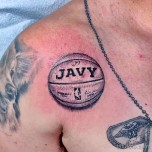 Фото тату на груди с изображением баскетбольного мяча и надписью 'JAVY', выполненное в черно-белом стиле.