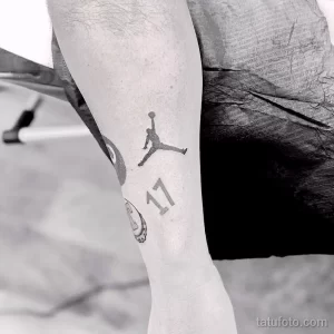 Фото минималистичной татуировки на руке с изображением логотипа Air Jordan и цифры 17, выполненной в черном цвете.