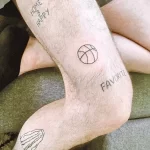 Фото тату на ноге с набором минималистичных татуировок: баскетбольный мяч, надпись 'Home is happy', сердце и другие символы.